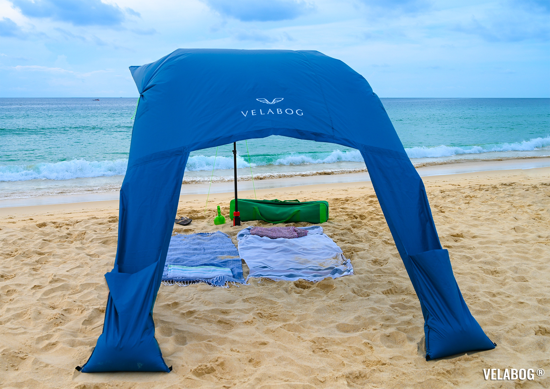 Beach sun sail Velabog Breeze, blue. Best beach sun canopy tent, high and airy sun shelter on the beach. Setup option for light to strong wind. View from behind.