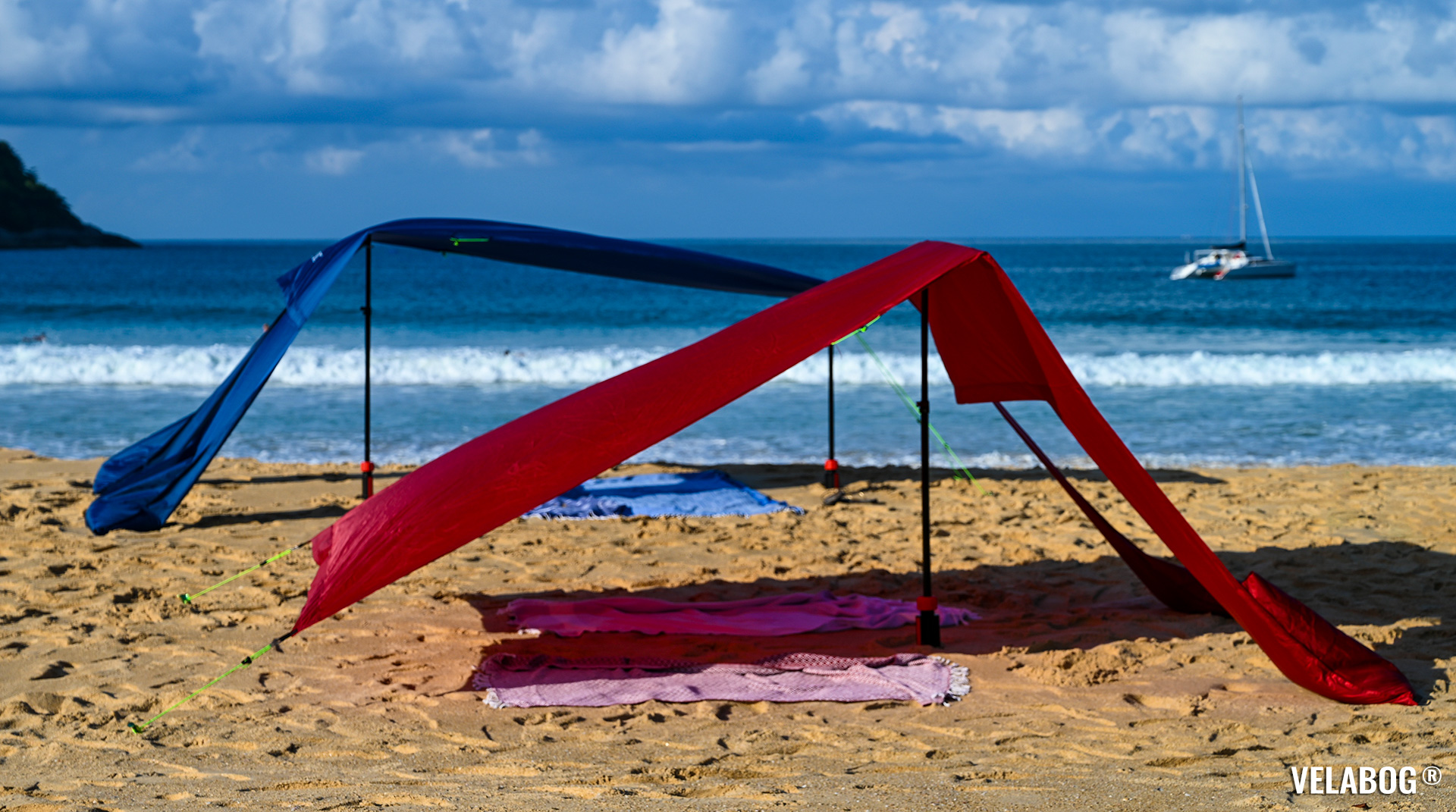 Two beach sun sails Velabog Breeze shows different setup options: without or with extension set. Best beach canopy tent on the beach with gusty wind. Side view.