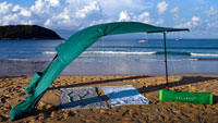 Beach sun sail Velabog Breeze, green, on the windy beach in Thailand. Beach sun sail, beach umbrella and beach tent in one. Best beach canopy. High quality, stylish. Long service life. Side view.