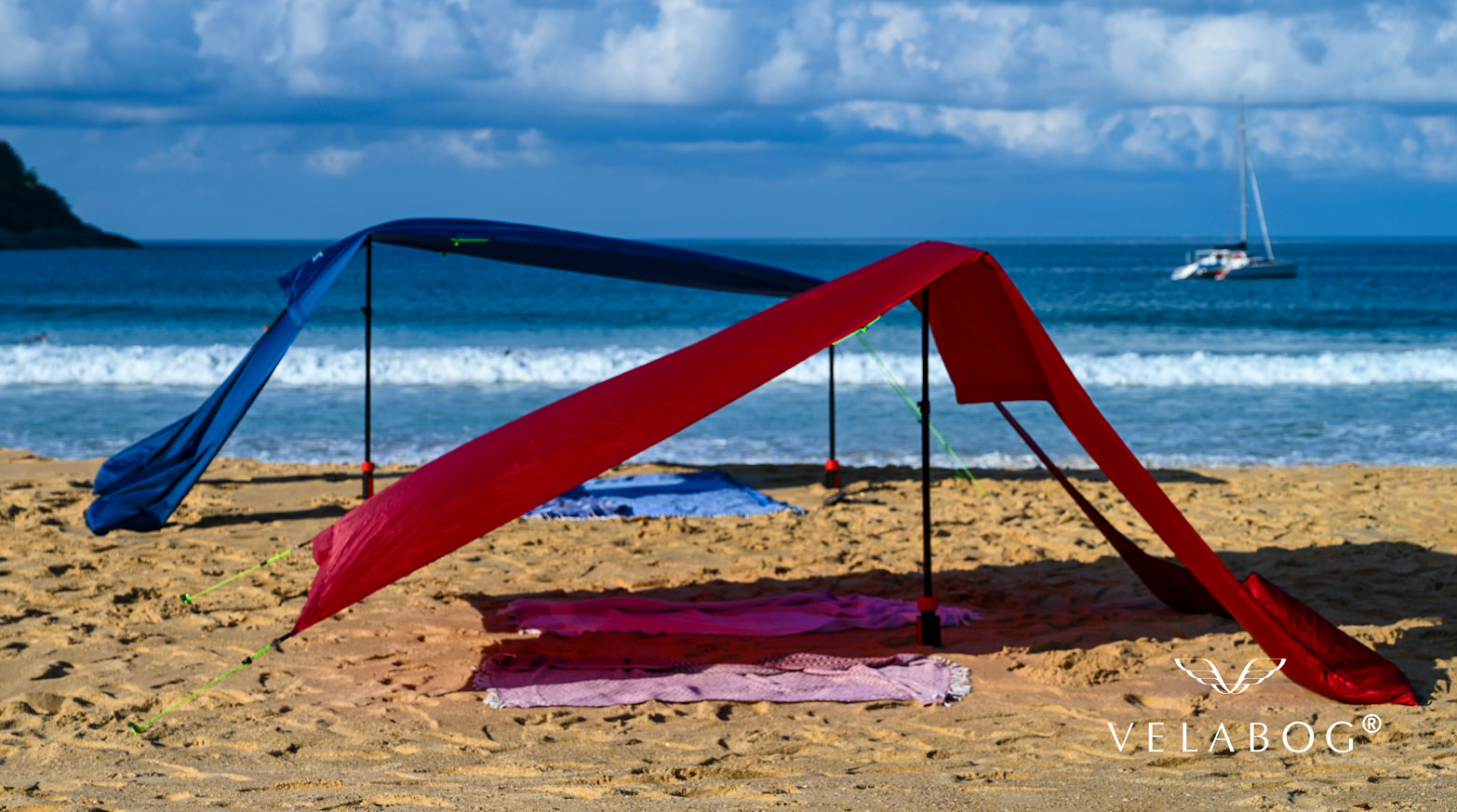 Grupa dwóch żagli słonecznych Velabog «Breeze». Ochrona przeciwsłoneczna na plaży z porywistym wiatrem. Różne możliwości montażu: bez lub z zestawem rozszerzonym. Widok z boku.