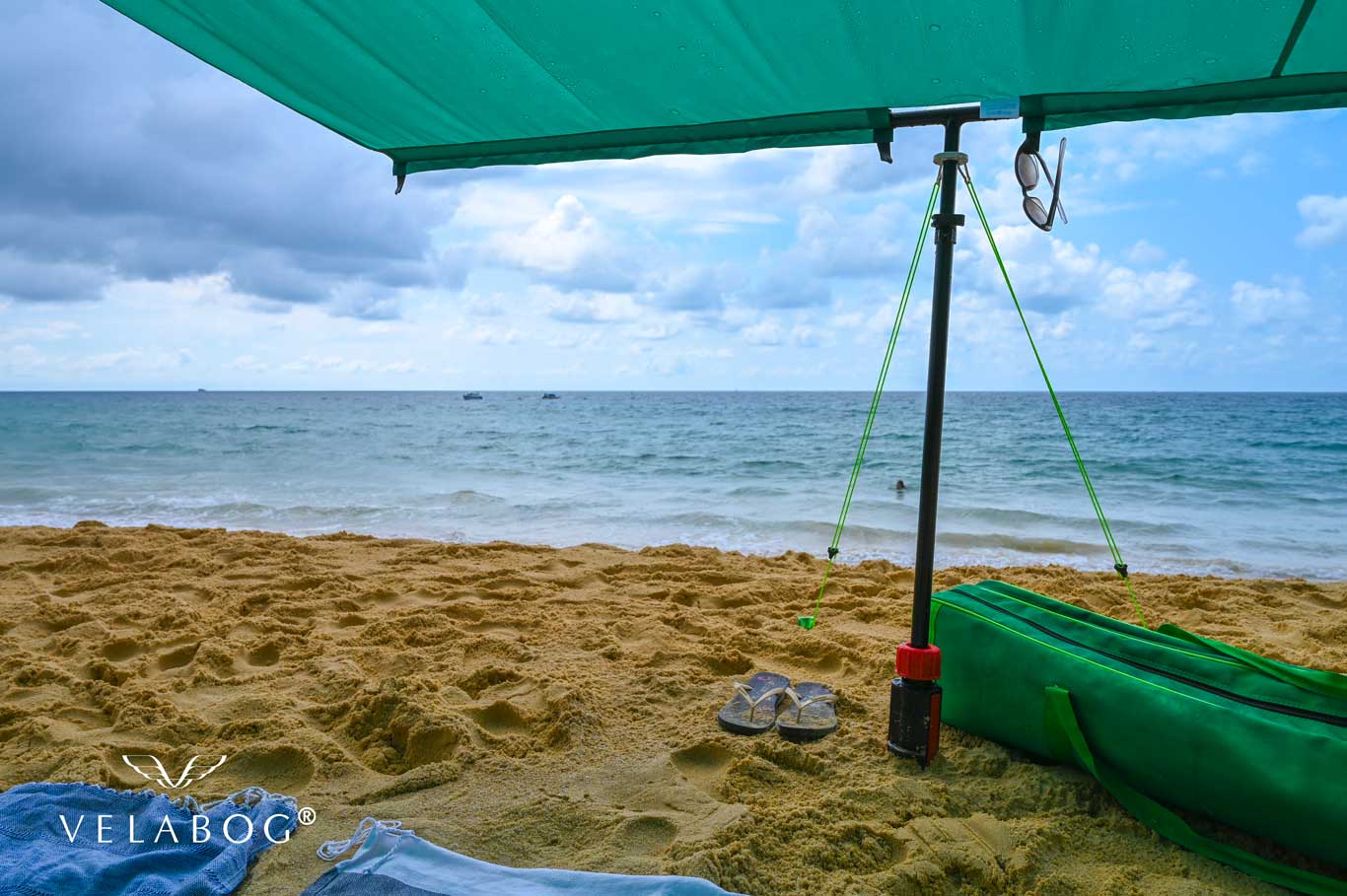 Velabog «Breeze» żagiel słoneczny - zielony. Najlepsza ochrona przed słońcem na plaży nawet podczas krótkiego deszczu. Opcja użytkowania - bez wiatru, przy lekkim lub porywistym wiatrze. Widok z dołu. Szczegóły.
