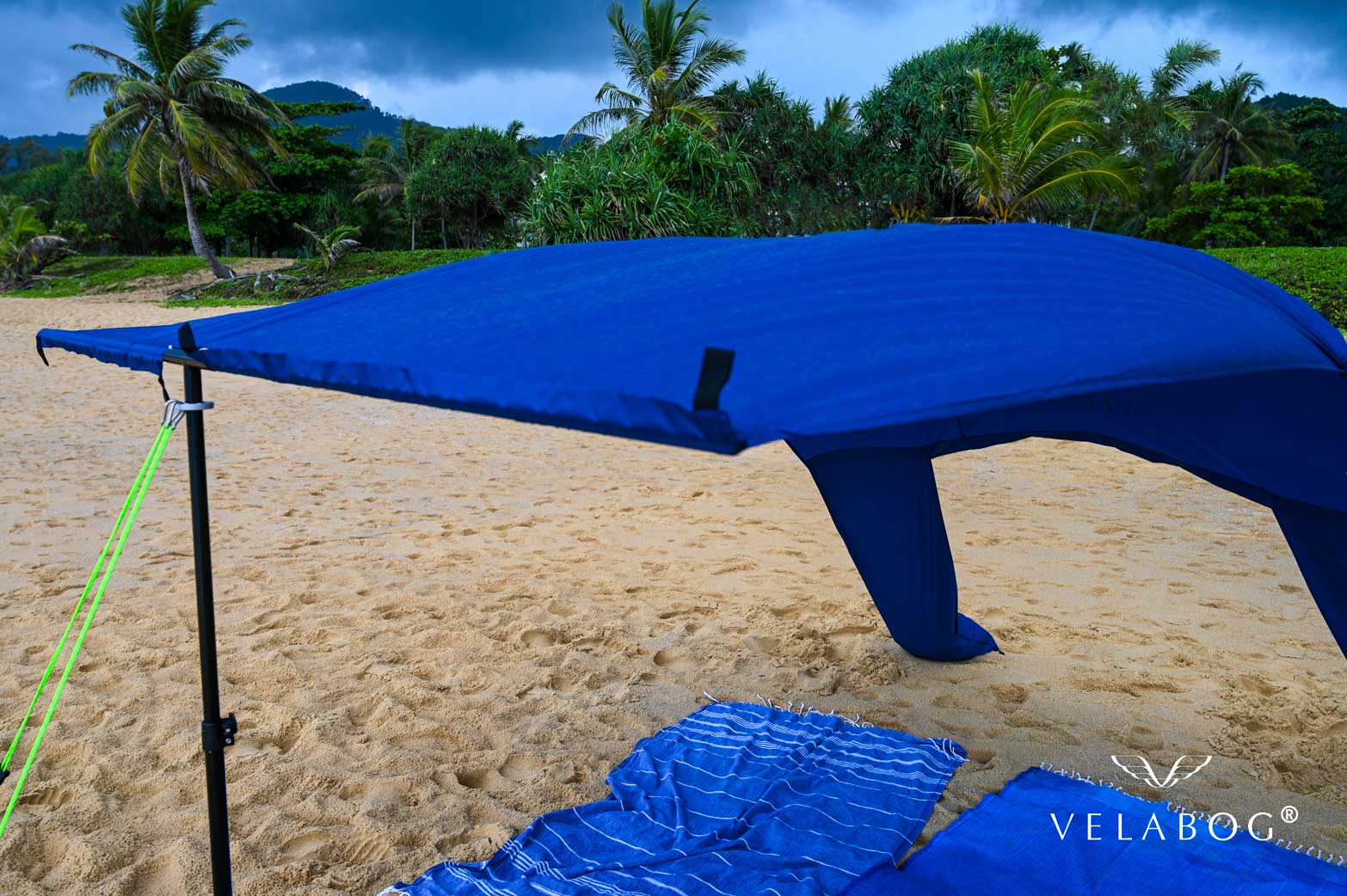 Toldo para playa Velabog Breeze azul nocturno en una playa de Tailandia durante un chubasco. La mejor refugio en la playa. Opción de montaje desde viento ligero a fuerte. Vista desde delante. Detalles.