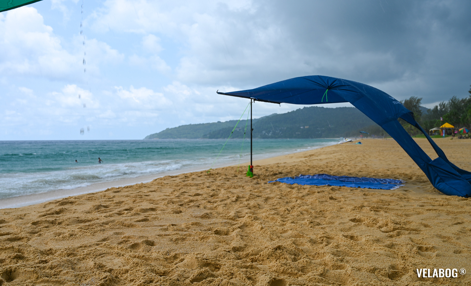 Strand Sonnensegel Strandzelt Velabog Breeze, nachtblau. Bester Sonnenschutz am Strand auch bei einem Regenschauer. Test Strand Sonnensegel Aufbauoption beim leichten bis starken Wind. Windstabil. Ansicht von der Seite.