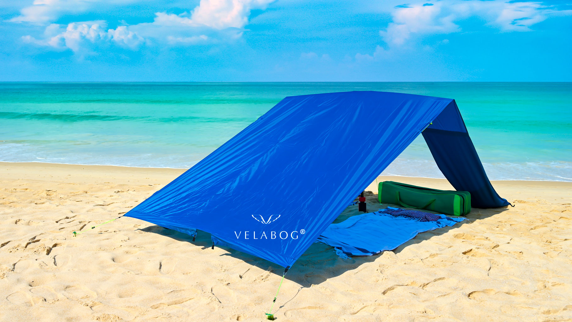 Toldo playa Velabog Breeze, azul, en una playa sin viento. Toldo playa, sombrilla y refugio de playa en uno. También puede emplearse sin viento. No se acumula calor. Muy grande y estable. Vista desde atrás.