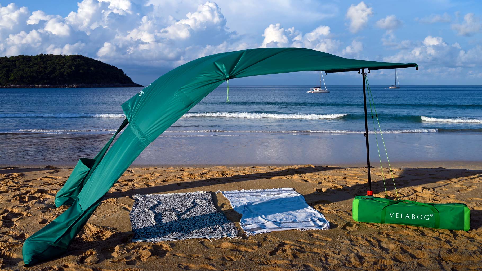 Żagiel słoneczny namiot plażowy Velabog Breeze, zielony, na plaży z wiatrem, w Tajlandii. Żagiel słoneczny, parasol plażowy i namiot plażowy w jednym. Wysoka jakość, trwałość i styl. Najlepsze zadaszenie na plażę. Widok z boku.